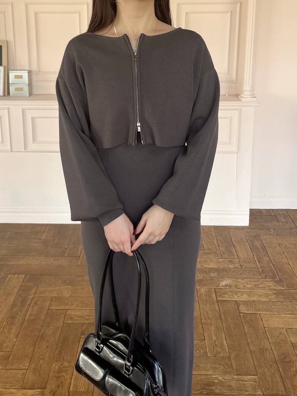 ブラック系のブーツ、グレー系のワンピース、ブラック系のハンドバッグを着用したレディースの冬コーディネートの3枚目の写真