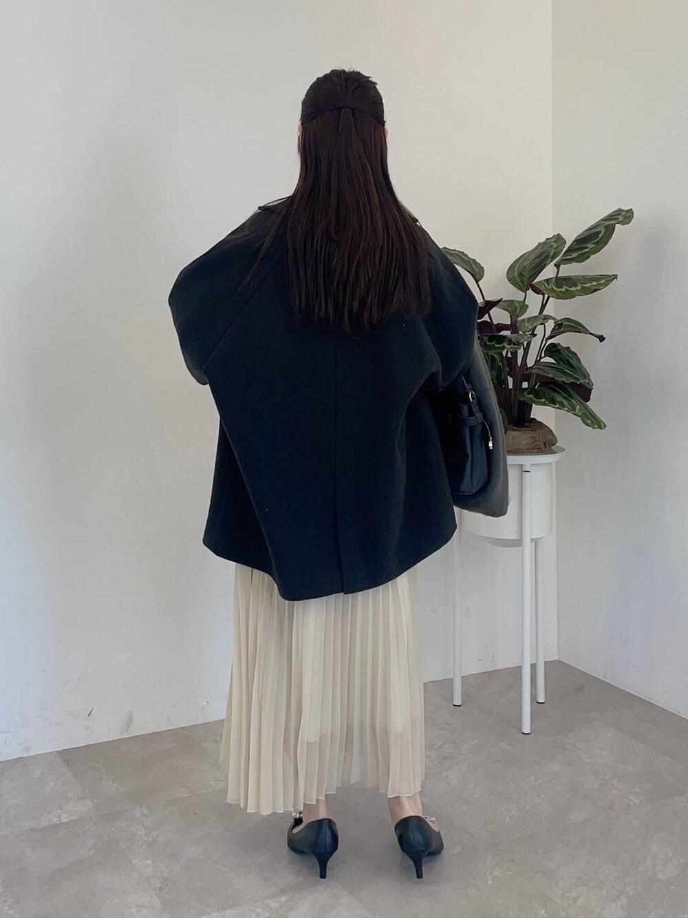 ブラック系のパンプス、ブラック系のショルダーバッグ、ブラック系のその他アウターを着用したレディースの冬コーディネートの2枚目の写真