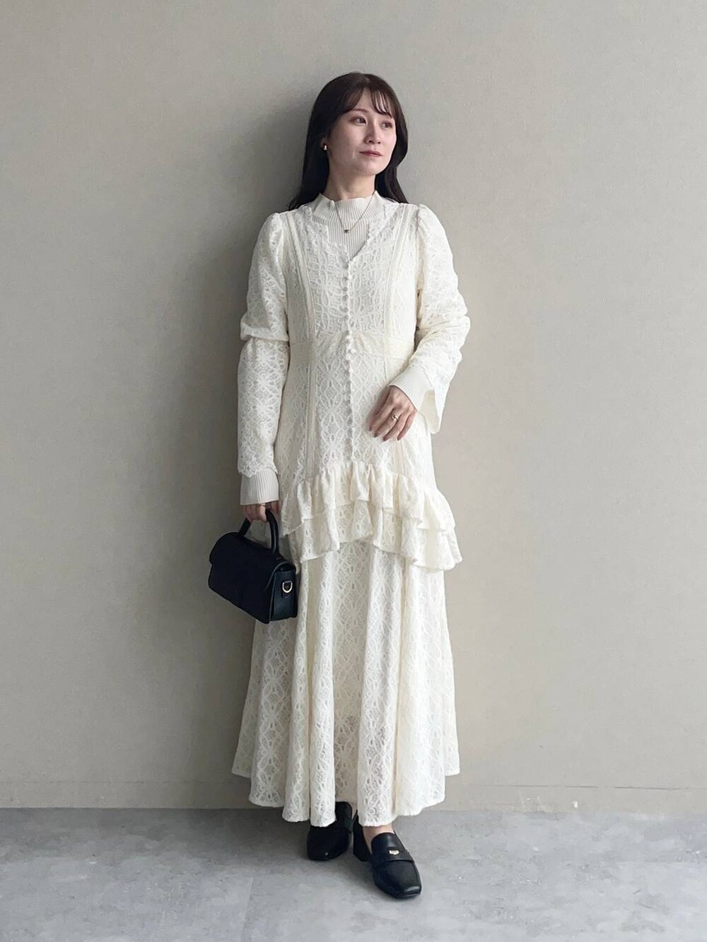 ホワイト系のニット/セーター、ホワイト系のワンピース、ブラック系のローファーを着用したレディースの秋コーディネートの3枚目の写真