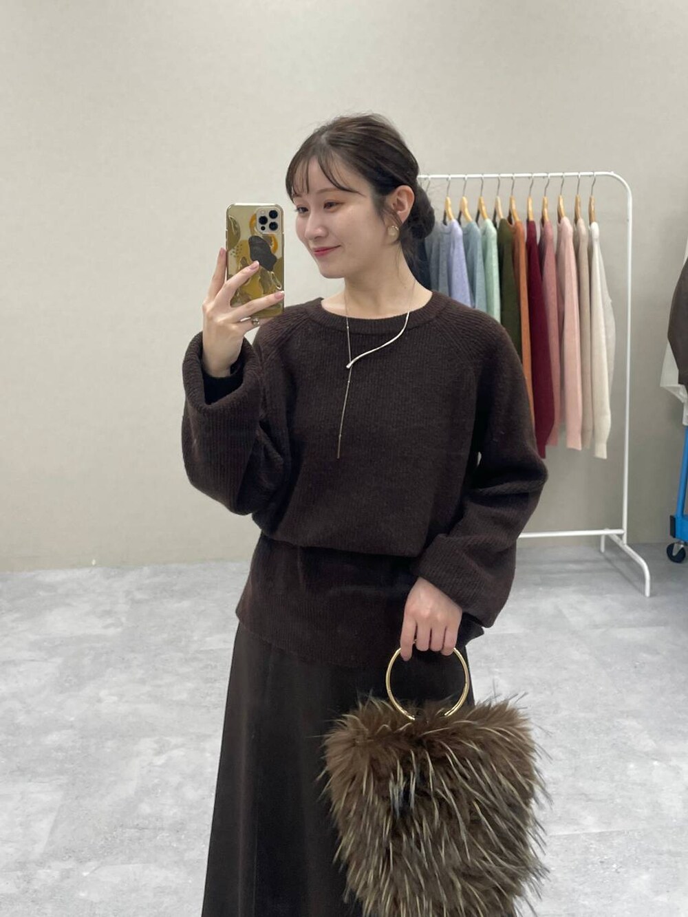 ブラウン系のスカート、レッド系のバレエシューズ、ブラウン系のニット/セーターを着用したレディースの秋コーディネートの2枚目の写真