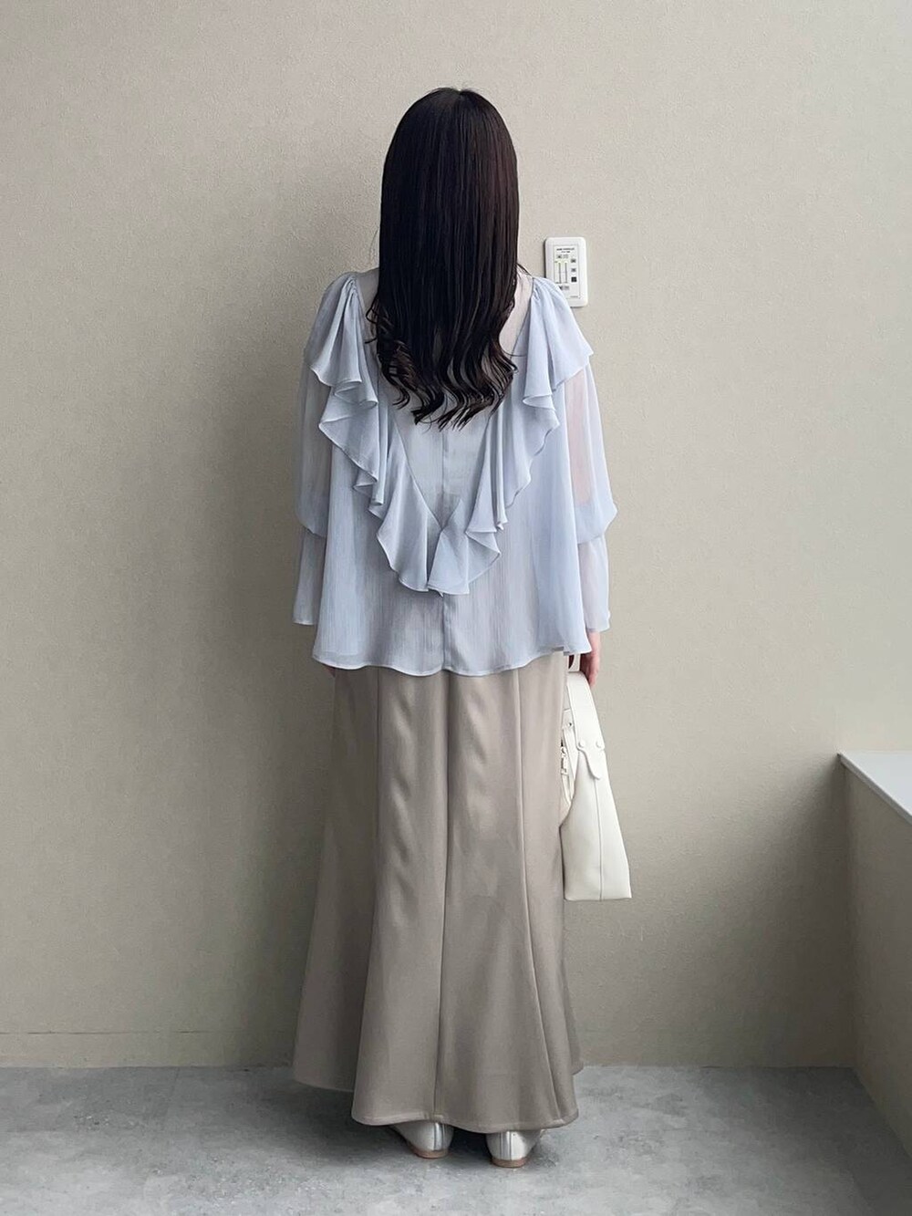 シルバー系のバレエシューズ、ホワイト系のショルダーバッグ、ゴールド系のネックレスを着用したレディースの春コーディネートの2枚目の写真