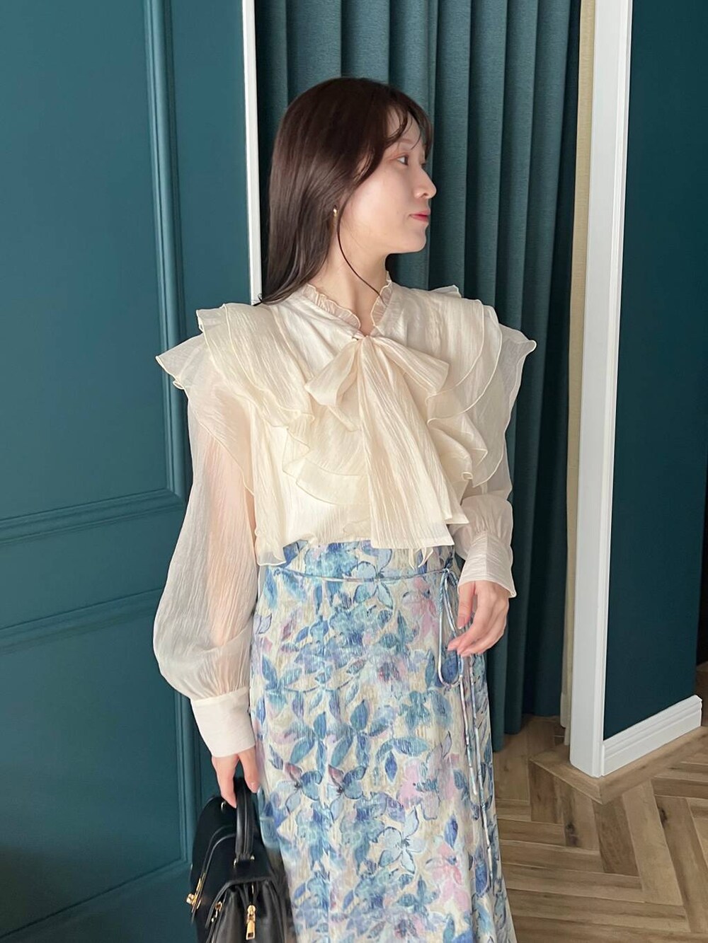 ホワイト系のシャツ/ブラウス、ホワイト系のスカート、ブラック系のブーツを着用したレディースの秋コーディネートの3枚目の写真