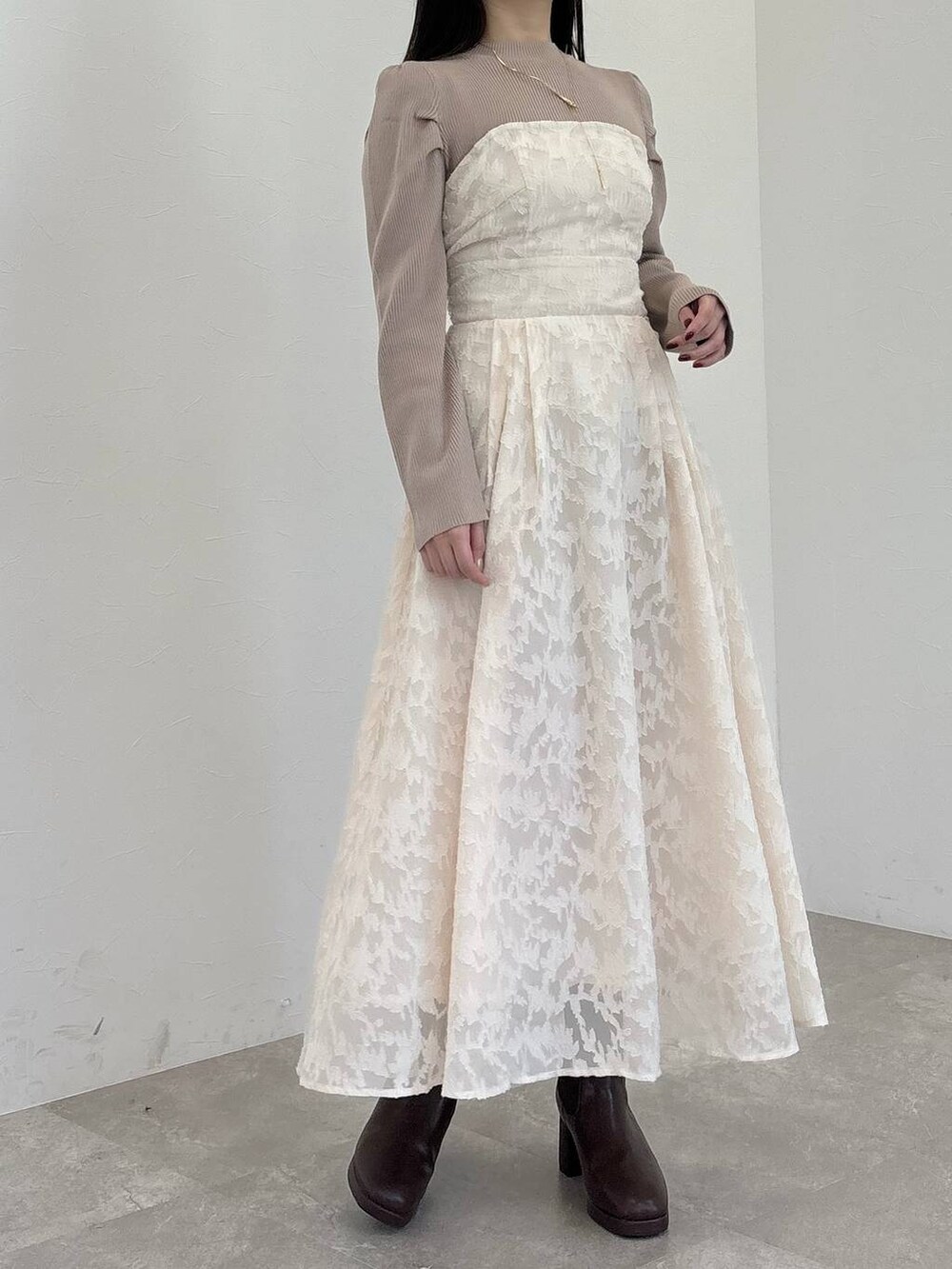 ブラウン系のブーツ、ブラウン系のハンドバッグ、ホワイト系のワンピースを着用したレディースの冬コーディネートの4枚目の写真