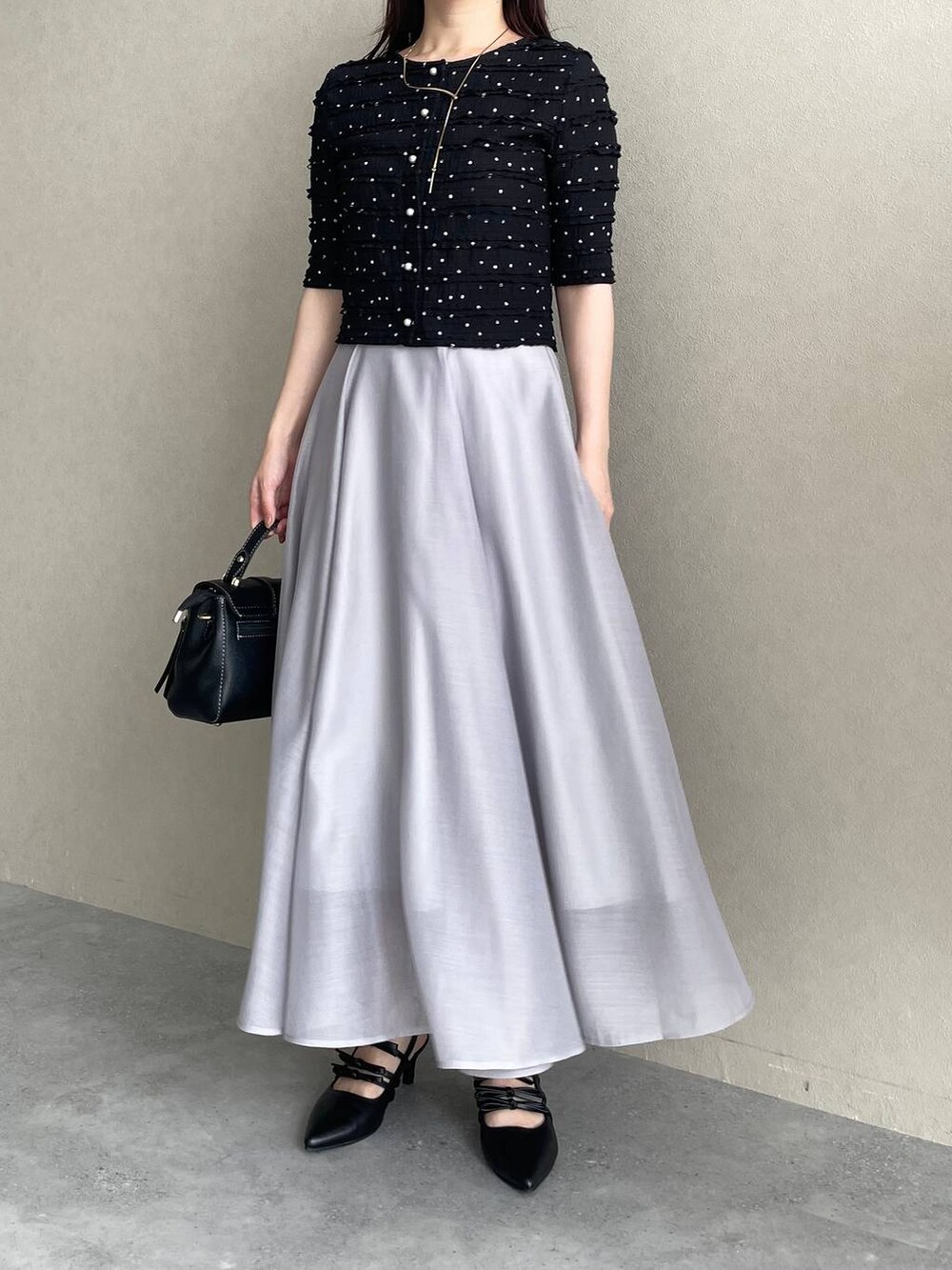 ブラック系のパンプス、ブラック系のショルダーバッグ、ブラック系のカーディガン/ボレロを着用したレディースの夏コーディネートの4枚目の写真