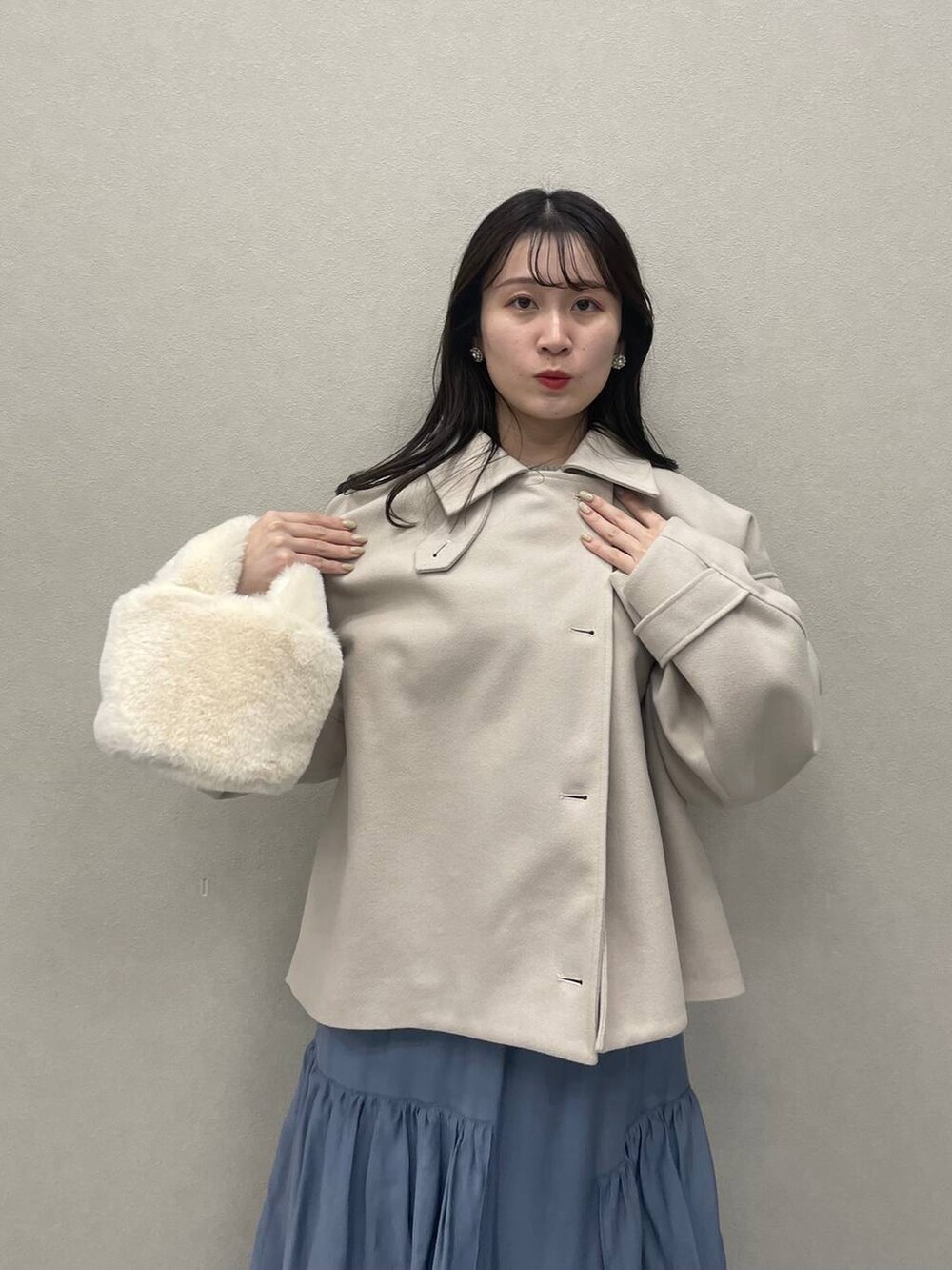 ホワイト系のその他アウター、ホワイト系のブーツ、ブルー系のスカートを着用したレディースの秋コーディネートの4枚目の写真