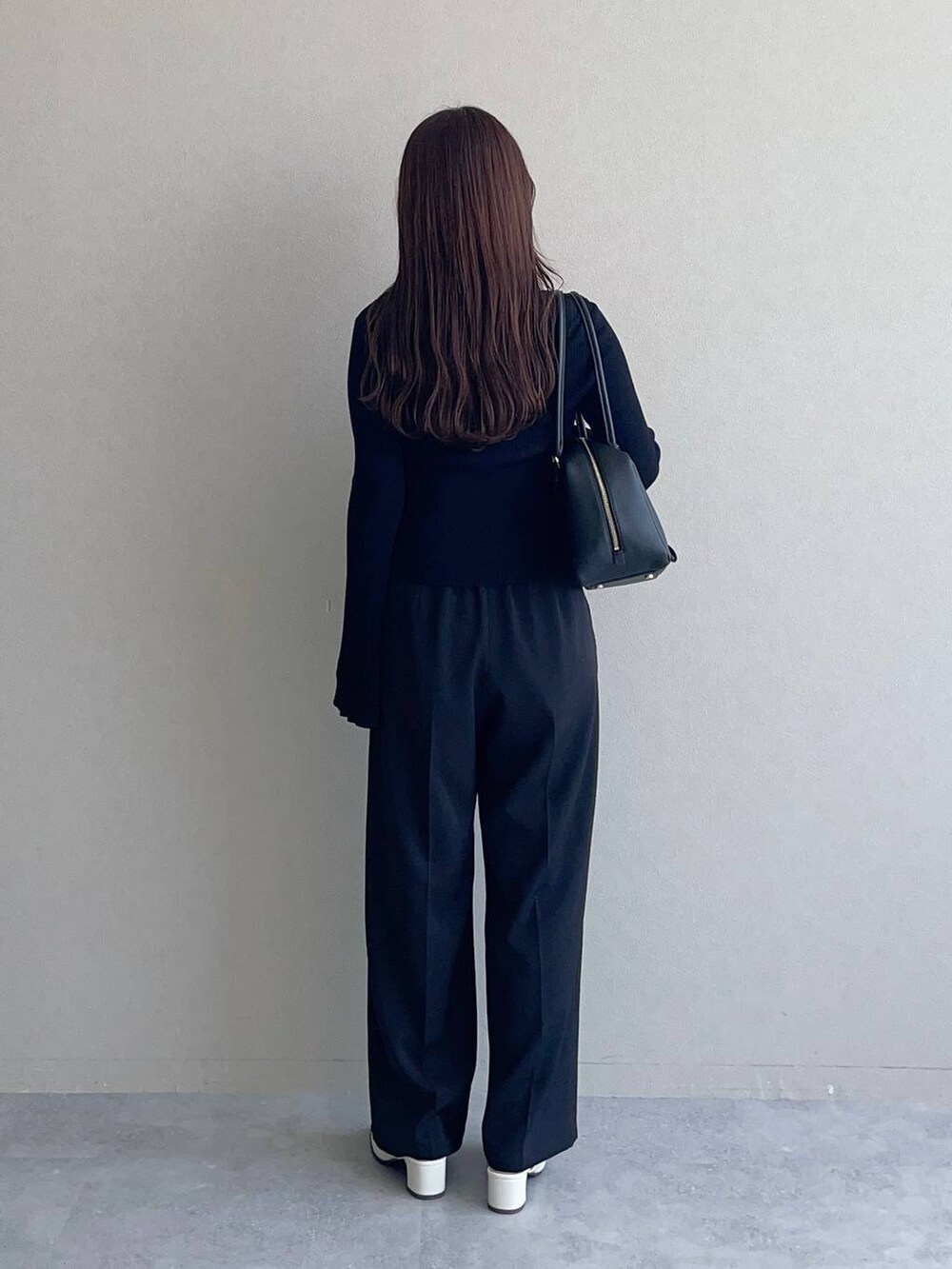 ブラック系のハンドバッグ、ブラック系のその他パンツ、ブラック系のカーディガン/ボレロを着用したレディースの秋コーディネートの2枚目の写真