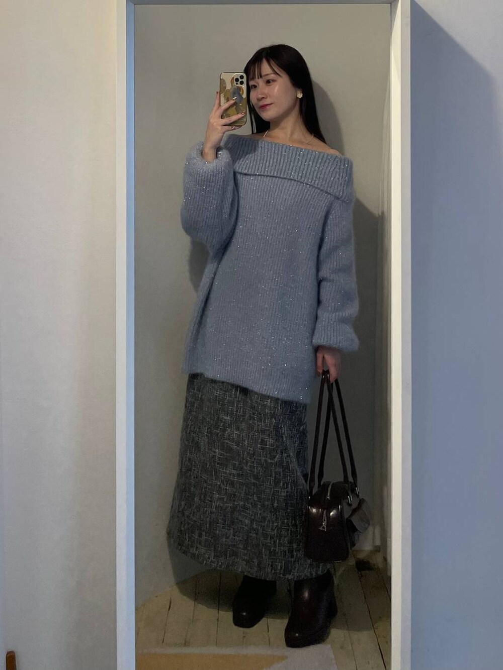 ブラウン系のブーツ、ブラウン系のハンドバッグ、ブラック系のワンピースを着用したレディースの冬コーディネートの3枚目の写真