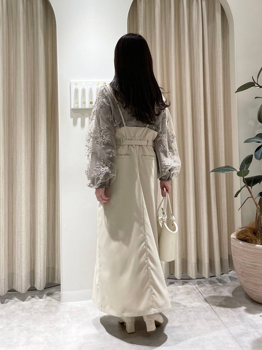 ベージュ系のスカート、ホワイト系のブーツ、ブラウン系のシャツ/ブラウスを着用したレディースの春コーディネートの2枚目の写真