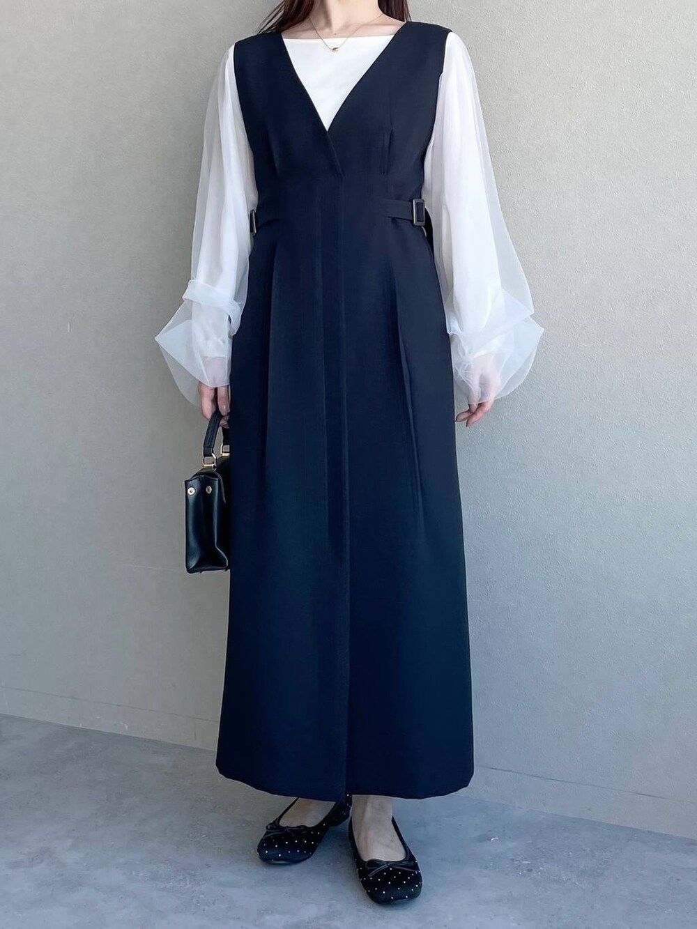 ブルー系のジャンパースカート、ブラック系のバレエシューズ、ホワイト系のTシャツ/カットソーを着用したレディースの冬コーディネートの4枚目の写真