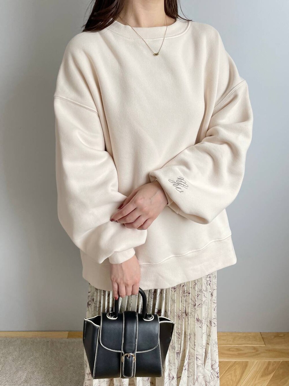 ブラック系のブーツ、ベージュ系のスカート、ホワイト系のスウェットを着用したレディースの秋コーディネートの3枚目の写真