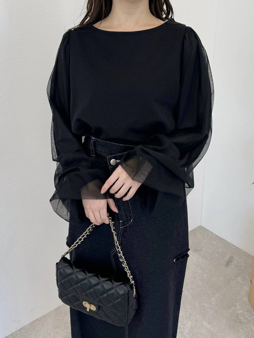 ブラック系のバレエシューズ、ブラック系のショルダーバッグ、ブラック系のスカートを着用したレディースの冬コーディネートの3枚目の写真