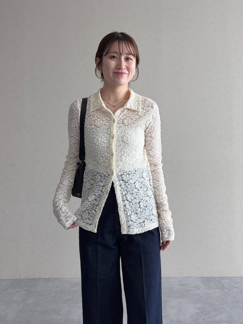 ベージュ系のトレンチコート、ブラック系のサンダル、ブルー系のデニムパンツを着用したレディースの冬コーディネートの6枚目の写真