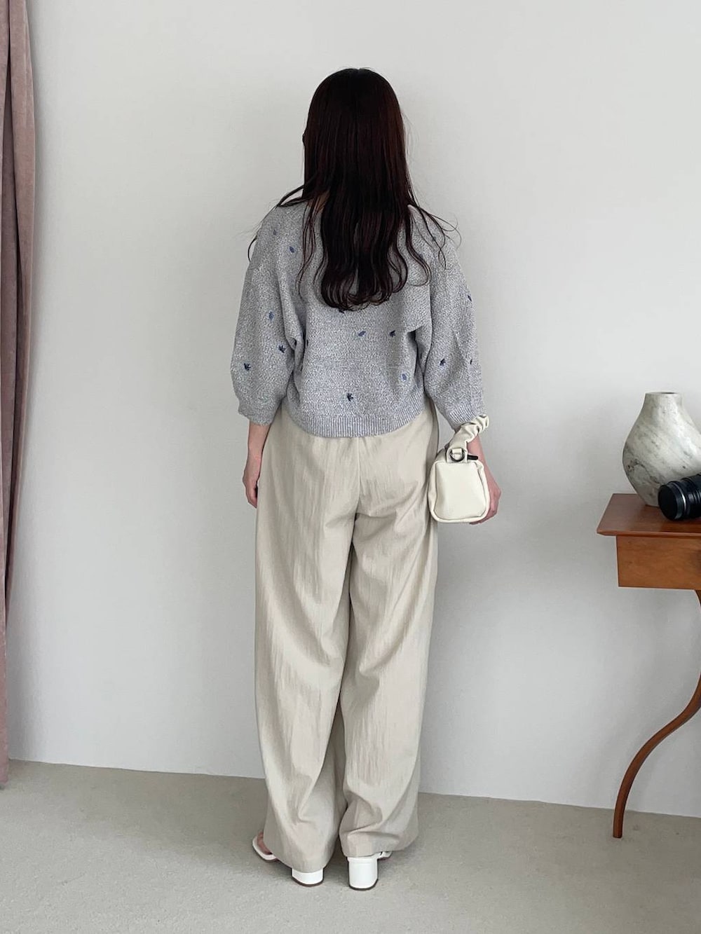 ベージュ系のその他パンツ、グレー系のカーディガン/ボレロ、ホワイト系のショルダーバッグを着用したレディースの春コーディネートの2枚目の写真