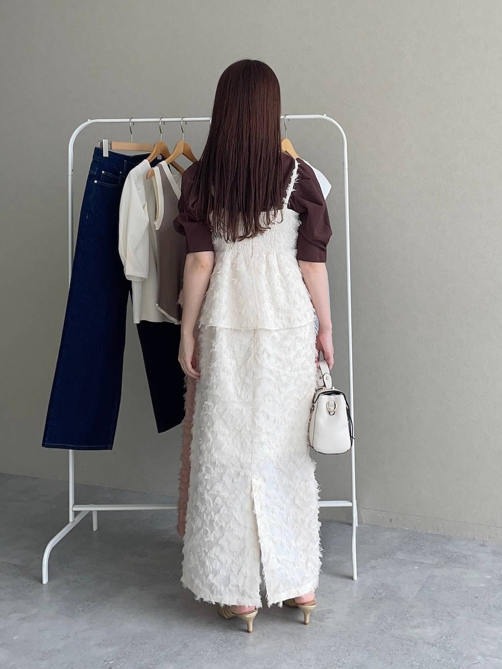 ゴールド系のパンプス、ホワイト系のショルダーバッグ、ブラウン系のTシャツ/カットソーを着用したレディースの夏コーディネートの2枚目の写真