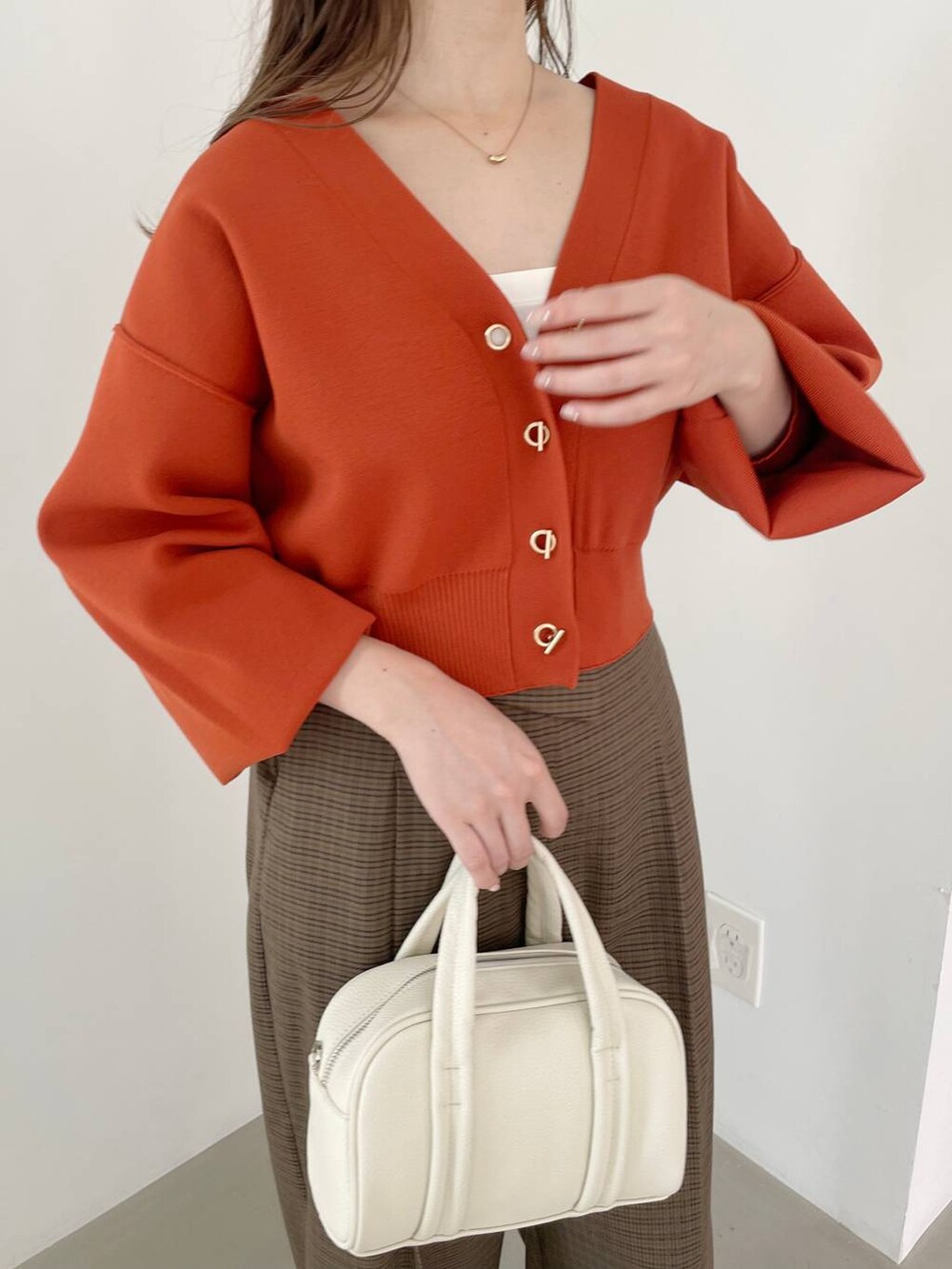 ホワイト系のボストンバッグ、ホワイト系のブーツ、ブラウン系のその他パンツを着用したレディースの秋コーディネートの3枚目の写真