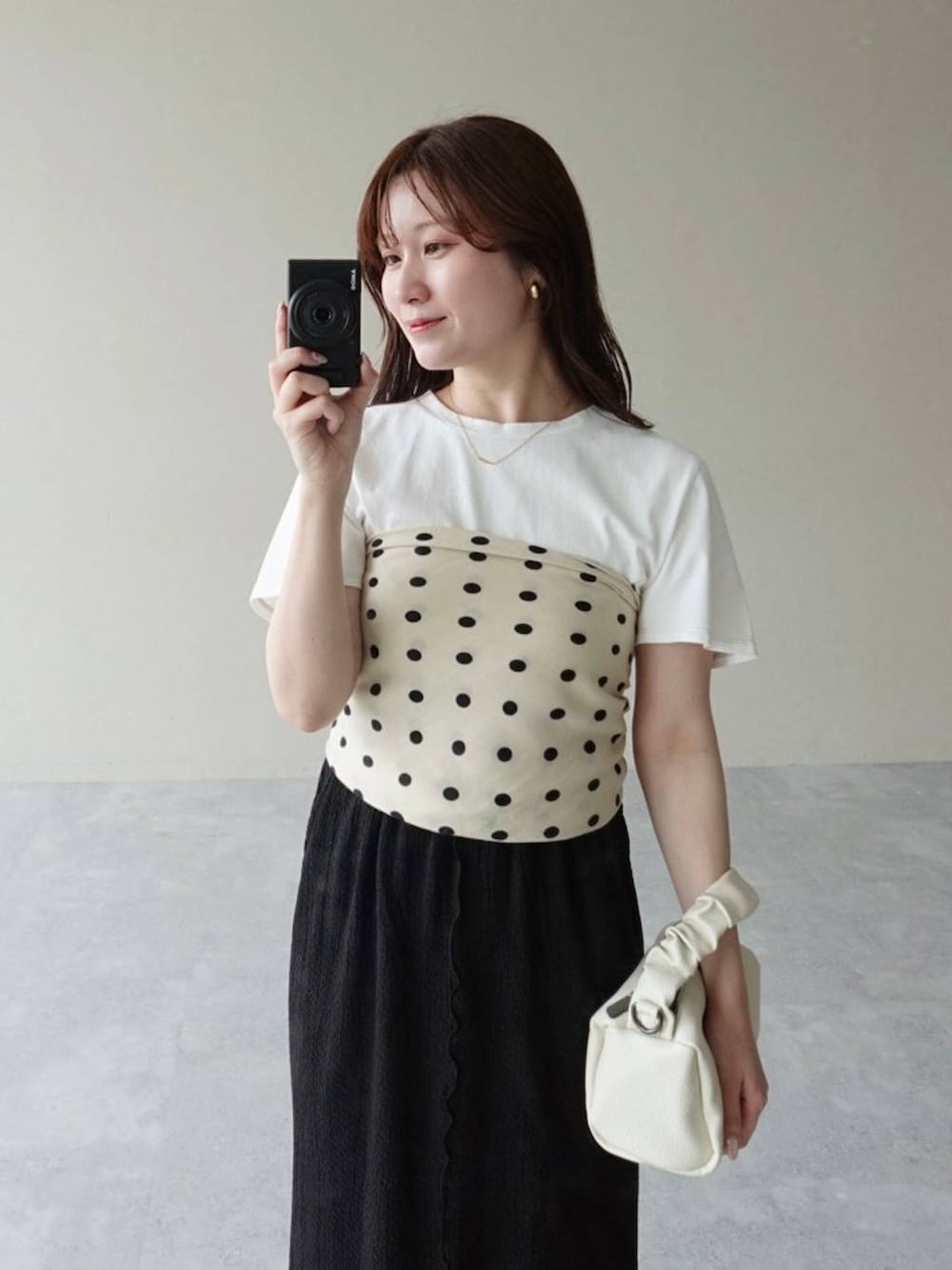 ブラック系のスカート、ブラック系のサンダル、ホワイト系のTシャツ/カットソーを着用したレディースの夏コーディネートの3枚目の写真