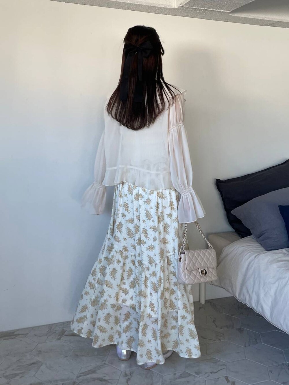 イエロー系のスカート、ホワイト系のシャツ/ブラウス、ホワイト系のショルダーバッグを着用したレディースの冬コーディネートの2枚目の写真