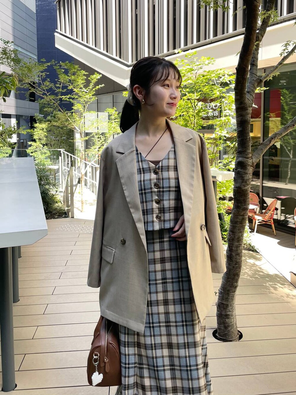 ベージュ系のテーラードジャケット、ブラウン系のショルダーバッグ、ベージュ系のワンピースを着用したレディースの秋コーディネートの3枚目の写真