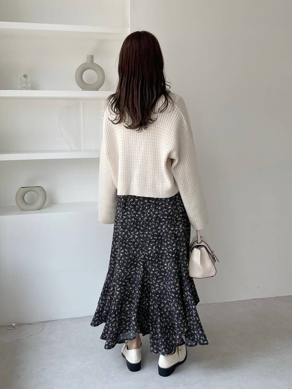 ホワイト系のその他シューズ、ホワイト系のハンドバッグ、ホワイト系のカーディガン/ボレロを着用したレディースの秋コーディネートの2枚目の写真