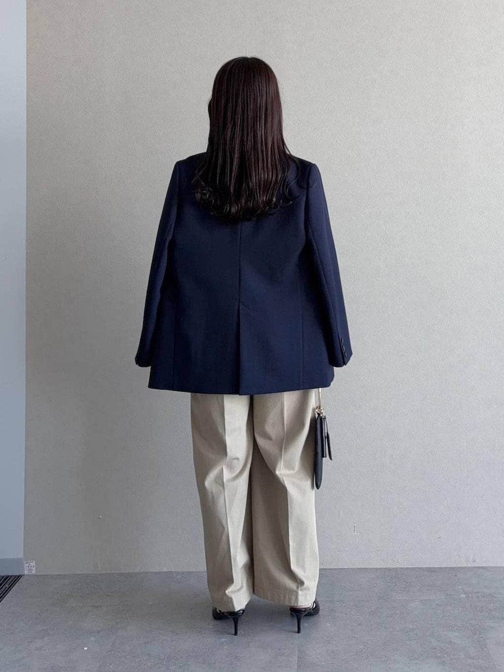 ブルー系のテーラードジャケット、ブラック系のサンダル、ブラック系のショルダーバッグを着用したレディースの春コーディネートの2枚目の写真