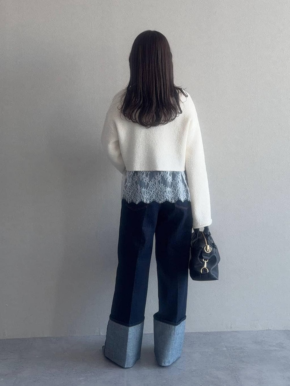 ブラウン系のボストンバッグ、ホワイト系のニット/セーター、ホワイト系のシャツ/ブラウスを着用したレディースの冬コーディネートの2枚目の写真