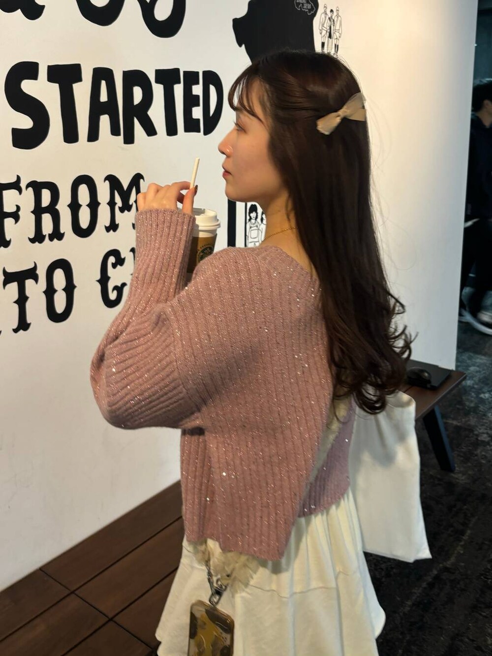 ホワイト系のスカート、ピンク系のニット/セーター、ベージュ系のスマホグッズを着用したレディースの秋コーディネートの3枚目の写真