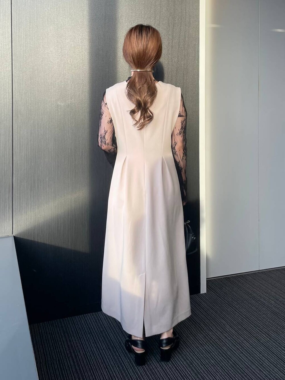 ブラック系のボストンバッグ、グレー系のドレス、ブラック系のパンプスを着用したレディースの秋コーディネートの2枚目の写真