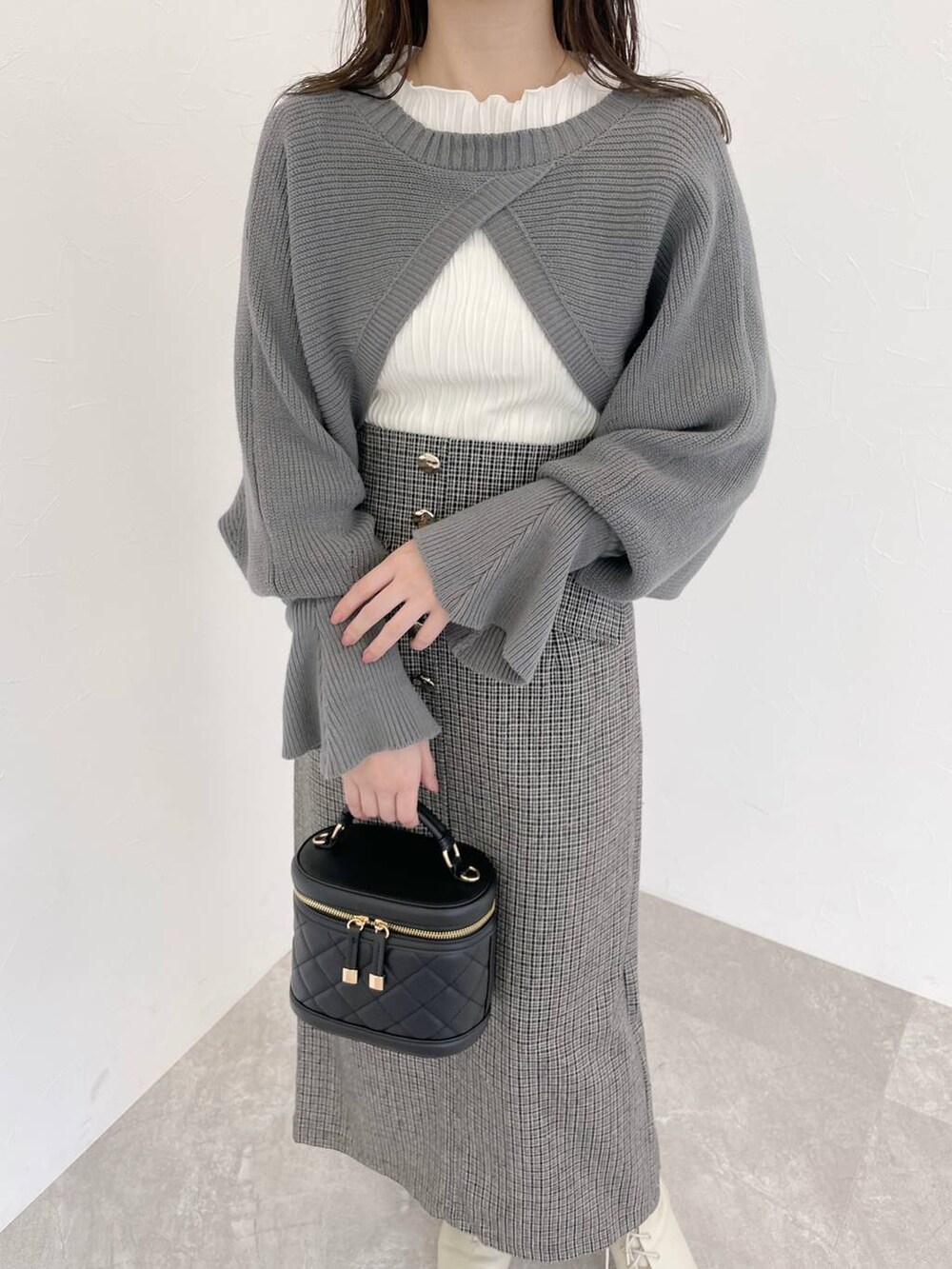 ホワイト系のブーツ、ブラック系のショルダーバッグ、ホワイト系のTシャツ/カットソーを着用したレディースの秋コーディネートの3枚目の写真