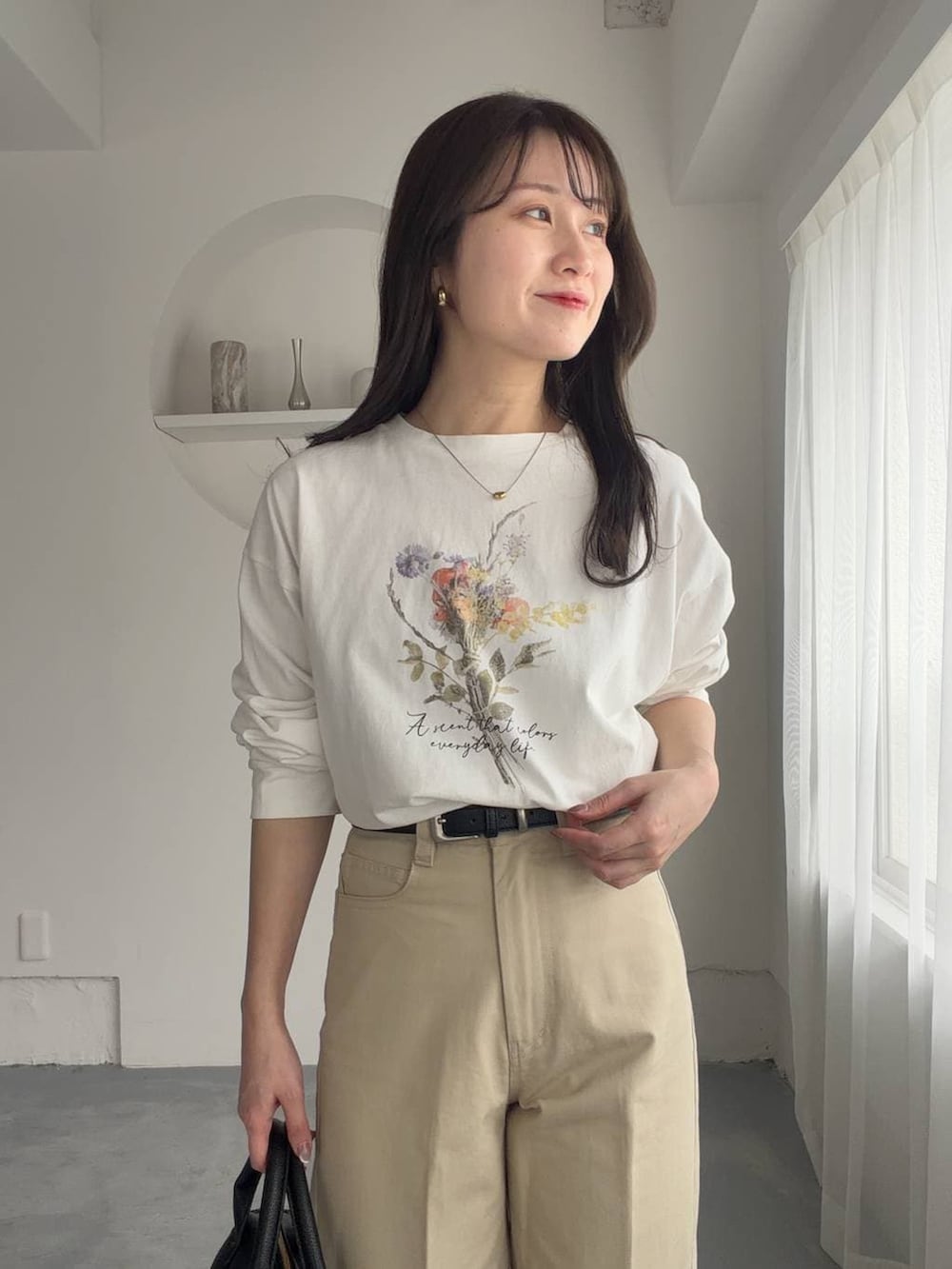 ブラック系のボストンバッグ、ブラック系のサンダル、ホワイト系のTシャツ/カットソーを着用したレディースの春コーディネートの4枚目の写真