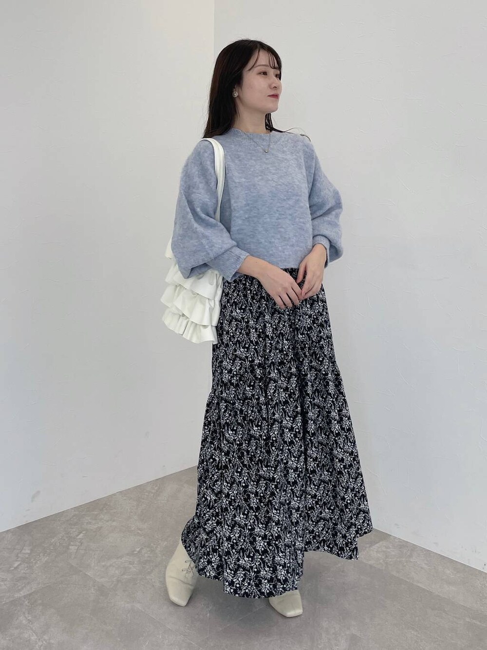 ホワイト系のブーツ、ブルー系のニット/セーター、ブラック系のワンピースを着用したレディースの秋コーディネートの2枚目の写真