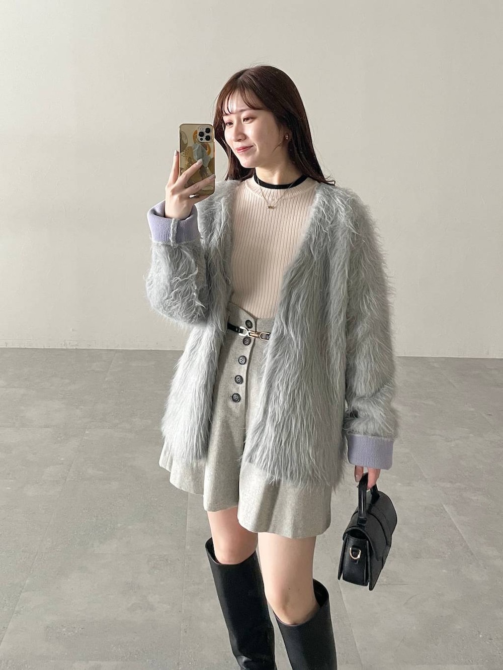 ホワイト系のニット/セーター、グレー系のカーディガン/ボレロ、グレー系のその他パンツを着用したレディースの秋コーディネートの3枚目の写真