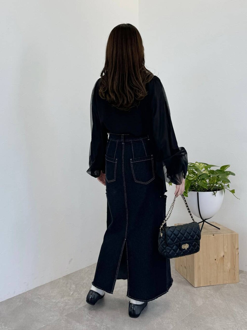 ブラック系のバレエシューズ、ブラック系のショルダーバッグ、ブラック系のスカートを着用したレディースの冬コーディネートの2枚目の写真