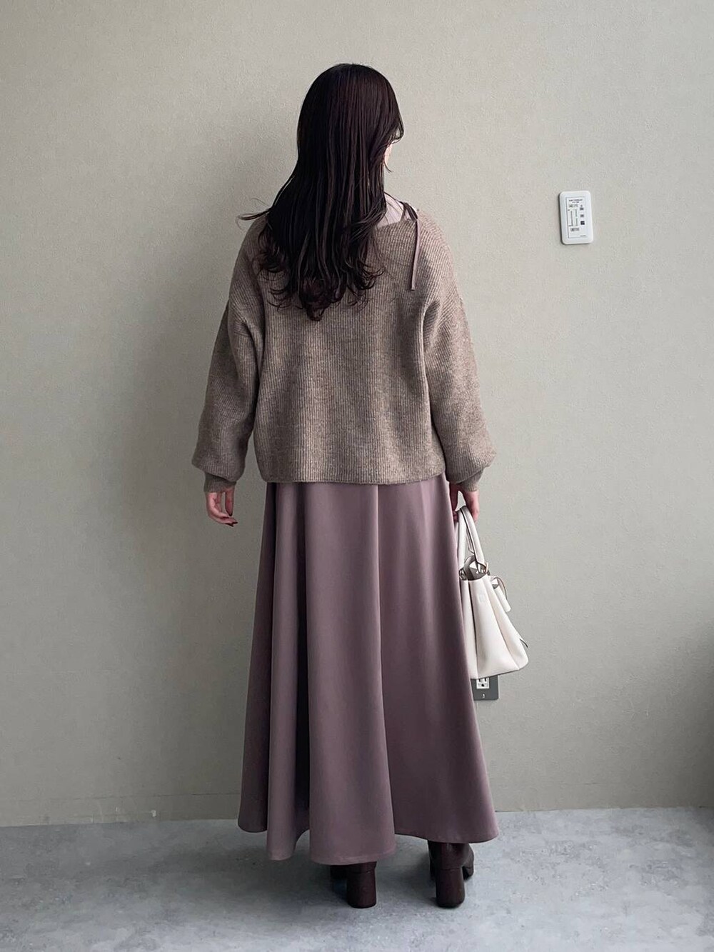 ブラウン系のブーツ、ベージュ系のニット/セーター、ホワイト系のブルゾンを着用したレディースの冬コーディネートの4枚目の写真