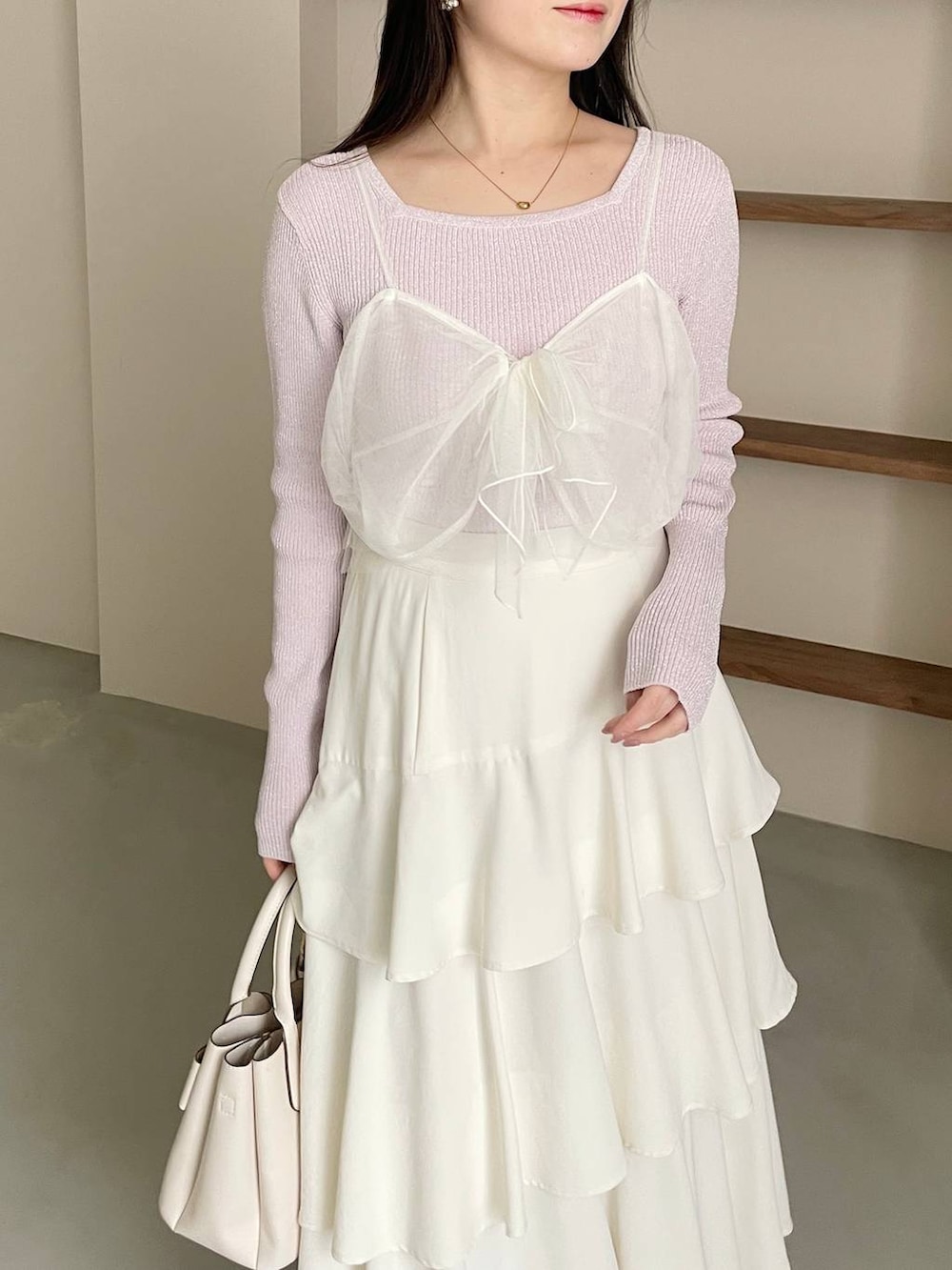 ホワイト系のスカート、ホワイト系のショルダーバッグ、ブラック系のパンプスを着用したレディースの冬コーディネートの5枚目の写真