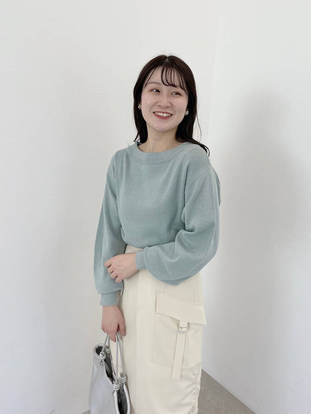 シルバー系のバレエシューズ、ホワイト系のスカート、グリーン系のニット/セーターを着用したレディースの春コーディネートの3枚目の写真