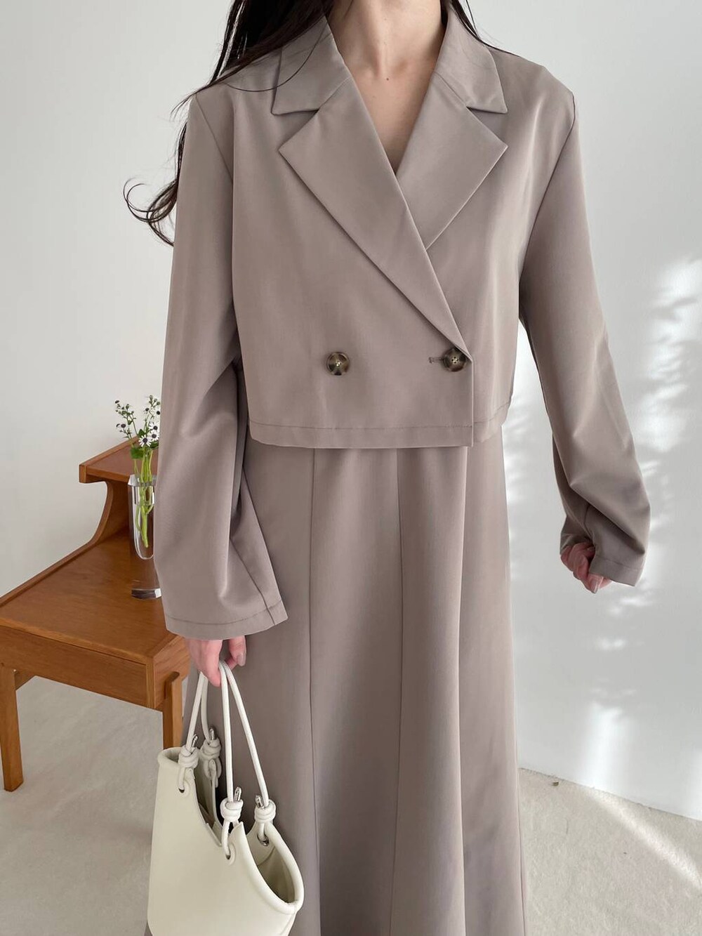 ブラウン系のテーラードジャケット、ブラウン系のワンピース、ホワイト系のブーツを着用したレディースの春コーディネートの3枚目の写真