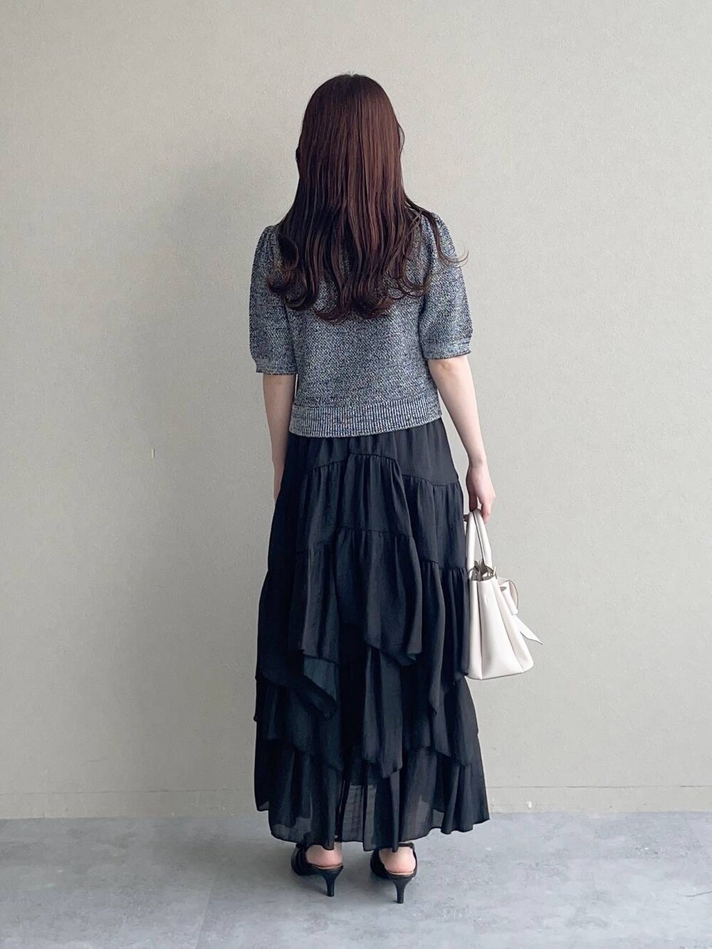 ホワイト系のショルダーバッグ、ブラック系のパンプス、ブラック系のカーディガン/ボレロを着用したレディースの夏コーディネートの2枚目の写真