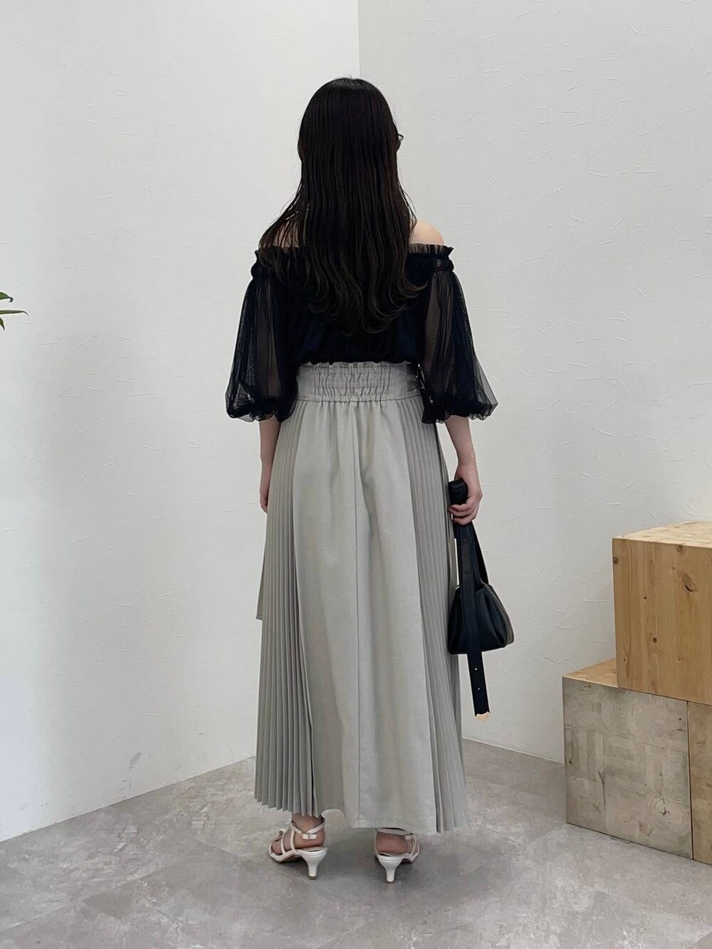 ブラック系のショルダーバッグ、ホワイト系のサンダル、ブルー系のシャツ/ブラウスを着用したレディースの夏コーディネートの2枚目の写真