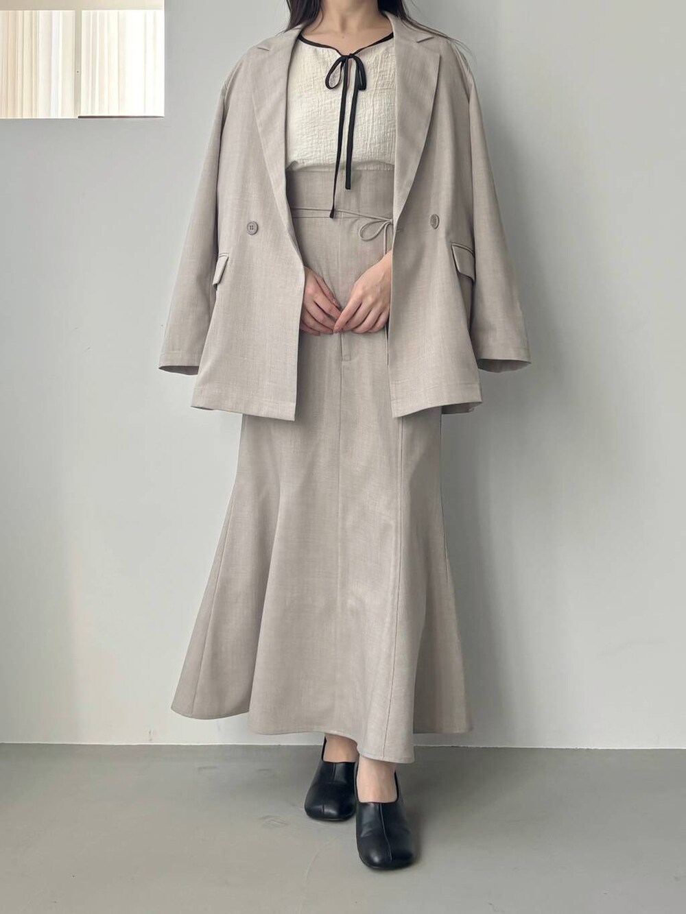 ブラック系のショルダーバッグ、ホワイト系のシャツ/ブラウス、ブラック系のパンプスを着用したレディースの冬コーディネートの6枚目の写真