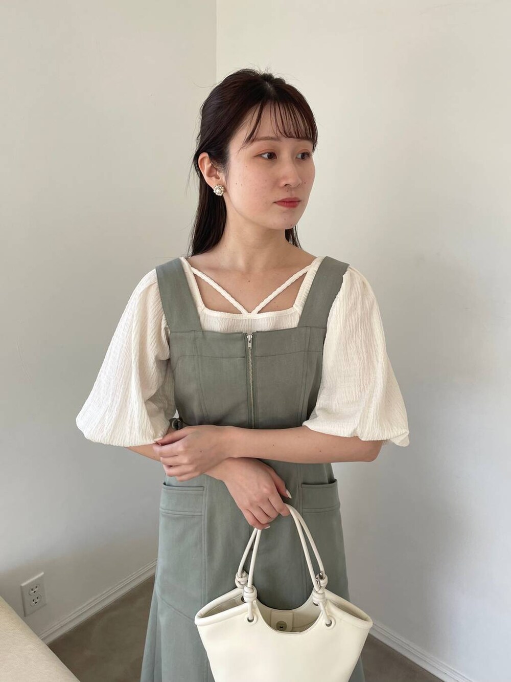 ホワイト系のTシャツ/カットソー、ホワイト系のサンダル、ホワイト系のハンドバッグを着用したレディースの春コーディネートの3枚目の写真