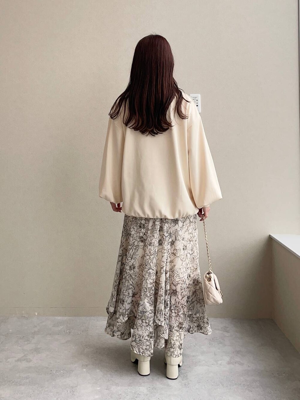 ホワイト系のスカート、ホワイト系のブーツ、ホワイト系のショルダーバッグを着用したレディースの秋コーディネートの2枚目の写真