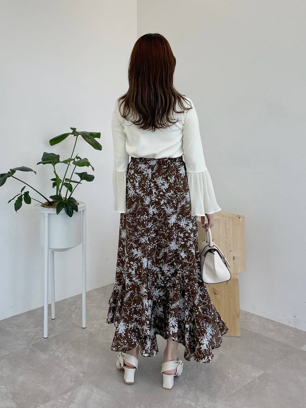 ブラウン系のスカート、ホワイト系のTシャツ/カットソー、ホワイト系のハンドバッグを着用したレディースの夏コーディネートの2枚目の写真