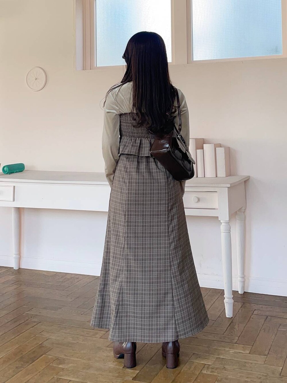 ブラウン系のブーツ、ブラウン系のスカート、ベージュ系のTシャツ/カットソーを着用したレディースの冬コーディネートの2枚目の写真