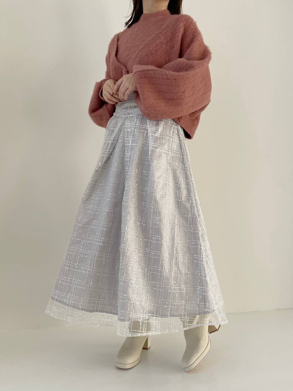 ホワイト系のハンドバッグ、ホワイト系のブーツ、ピンク系のカーディガン/ボレロを着用したレディースの秋コーディネートの4枚目の写真