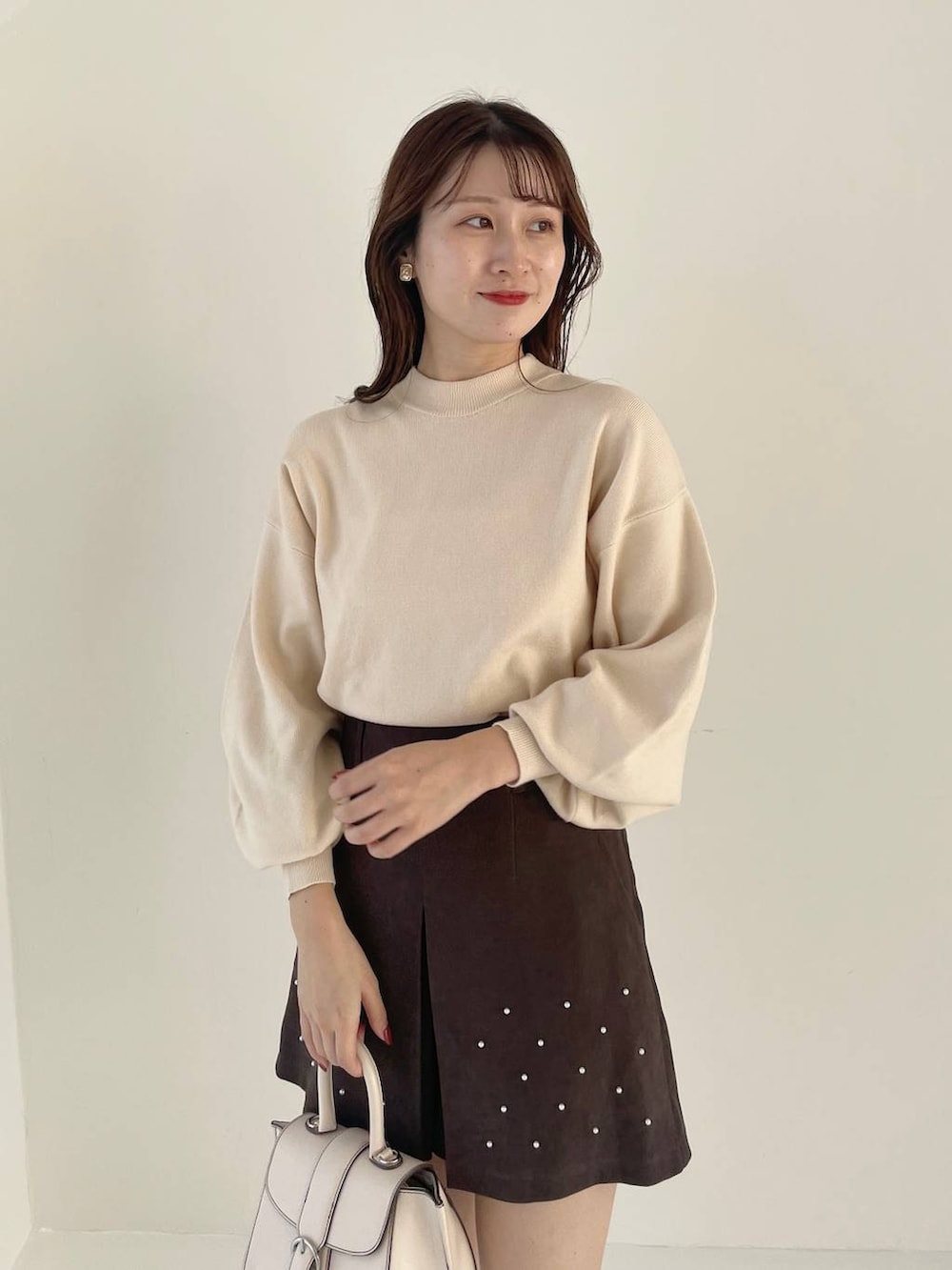 ホワイト系のハンドバッグ、ホワイト系のブーツ、ホワイト系のニット/セーターを着用したレディースの秋コーディネートの6枚目の写真