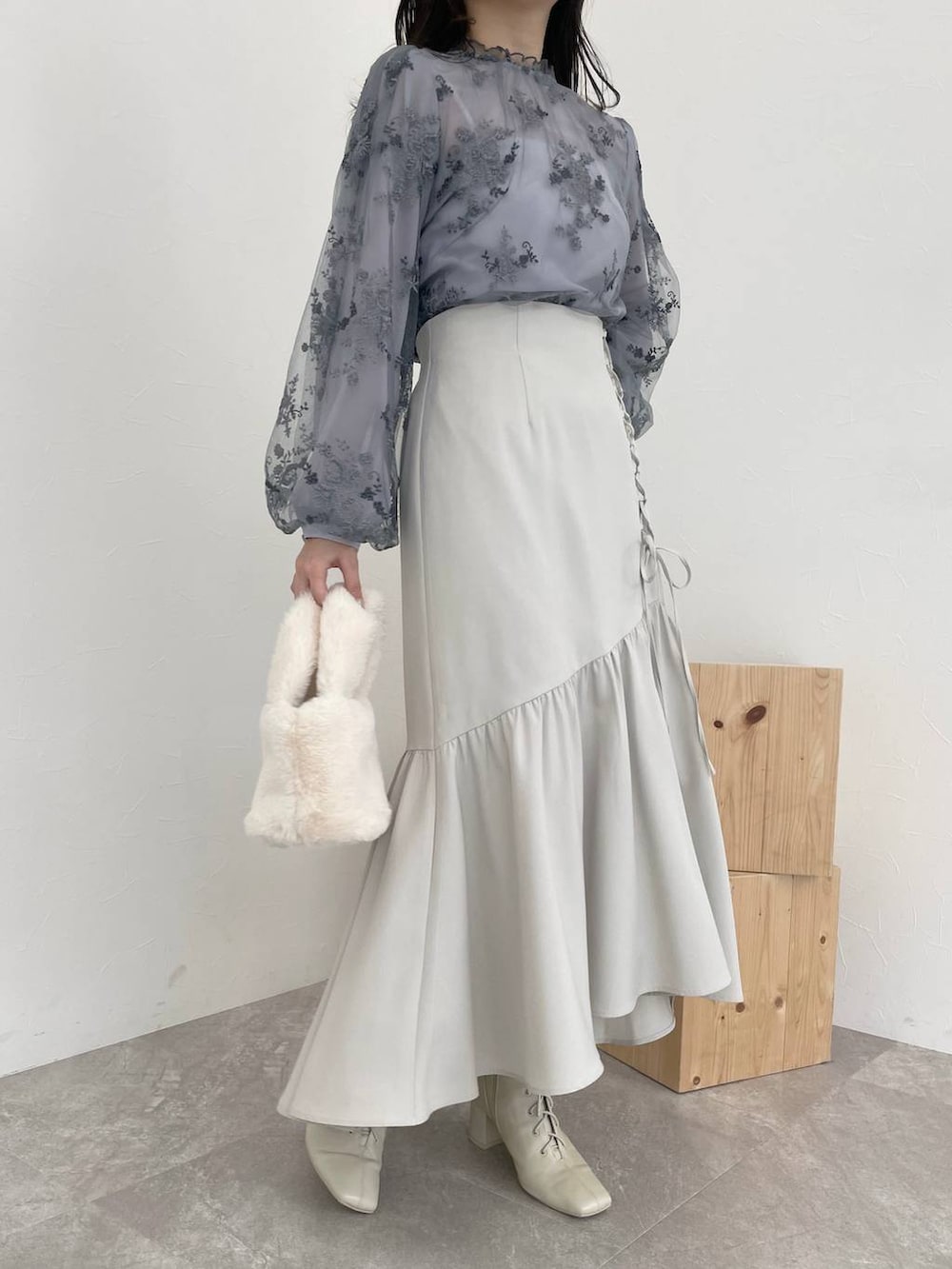 ホワイト系のチェスターコート、ホワイト系のブーツ、ブルー系のシャツ/ブラウスを着用したレディースの秋コーディネートの7枚目の写真