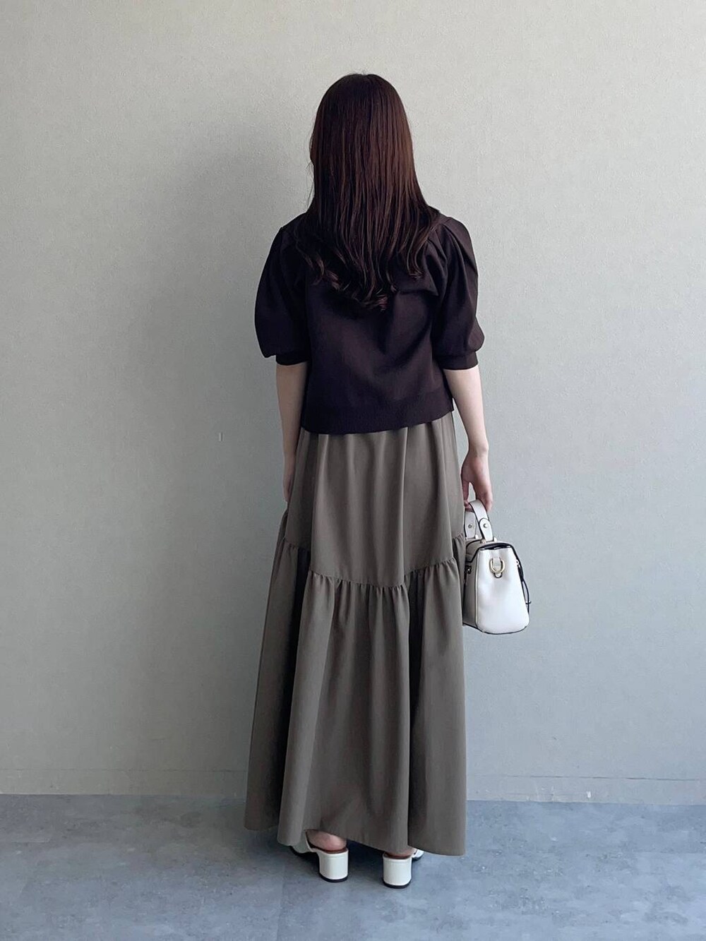 ホワイト系のショルダーバッグ、ブラウン系のカーディガン/ボレロ、ブラウン系のワンピースを着用したレディースの夏コーディネートの2枚目の写真