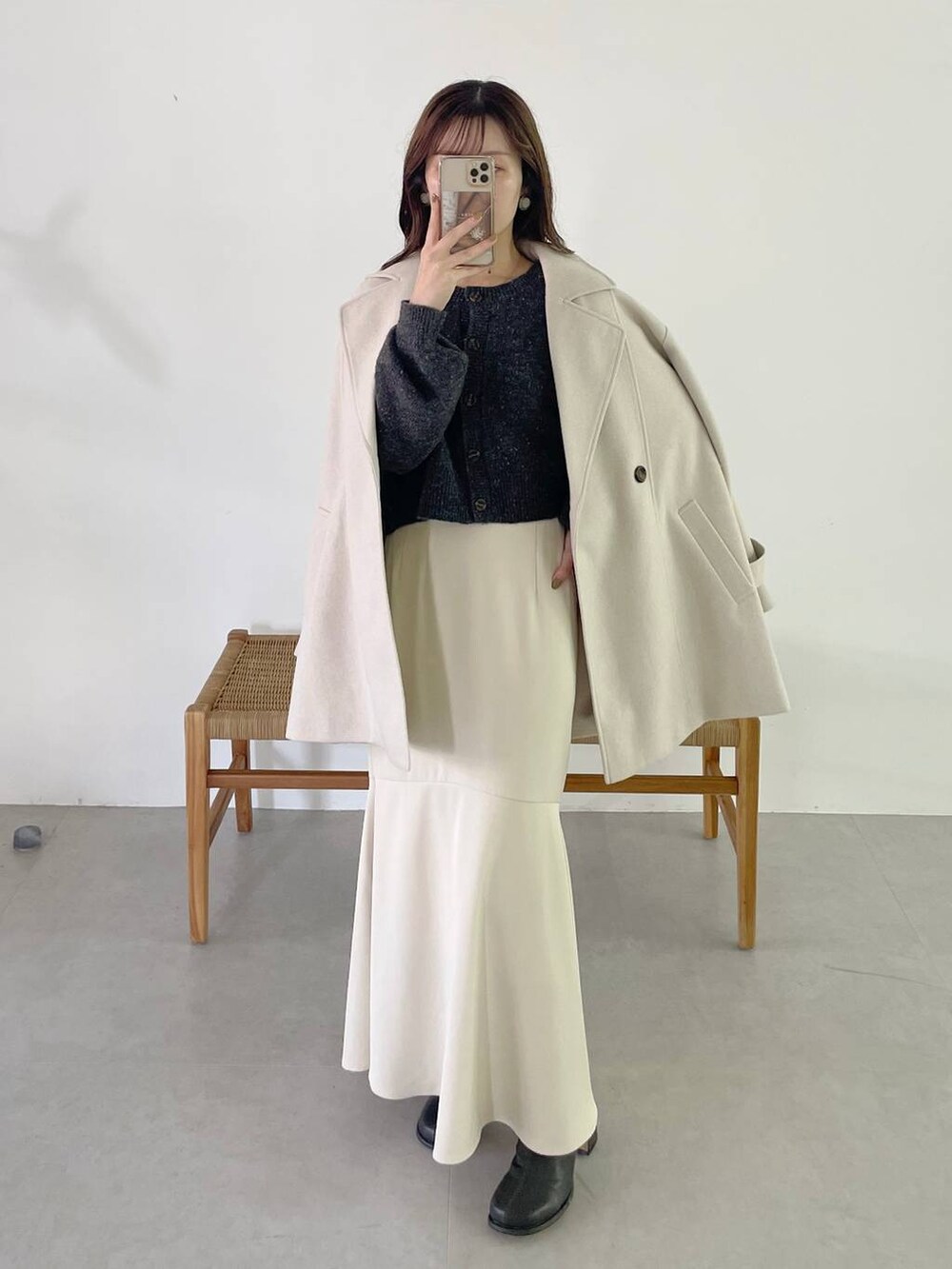 ホワイト系のチェスターコート、ホワイト系のハンドバッグ、グレー系のブーツを着用したレディースの秋コーディネートの4枚目の写真