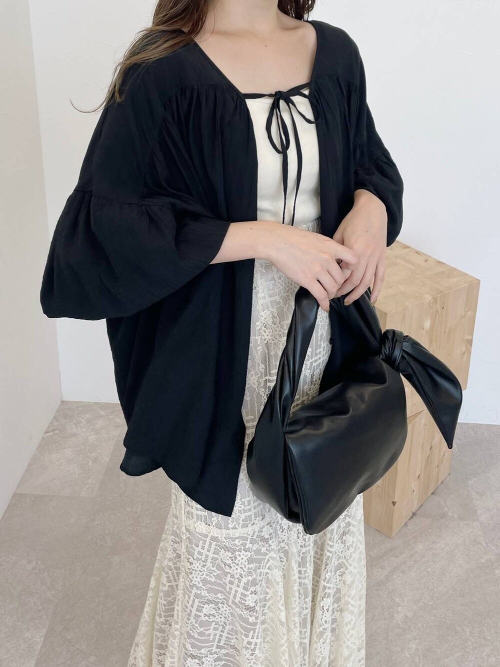 ホワイト系のタンクトップ、ブラック系のシャツ/ブラウス、ブラック系のハンドバッグを着用したレディースの秋コーディネートの3枚目の写真