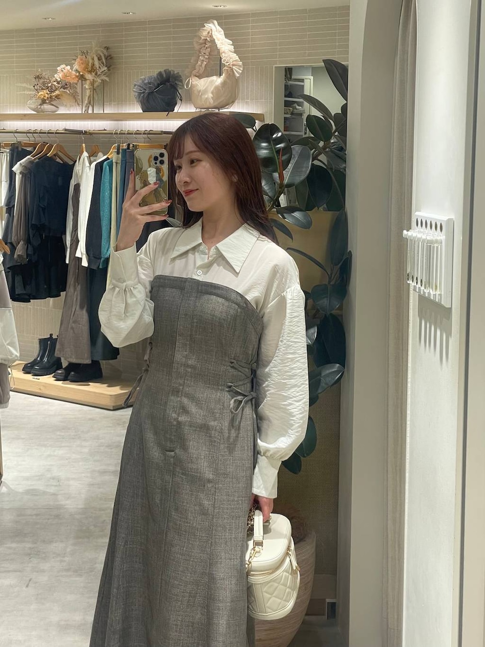 ホワイト系のブーツ、ブラウン系のワンピース、ホワイト系のショルダーバッグを着用したレディースの秋コーディネートの3枚目の写真